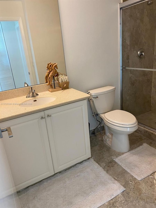 bathroom with vanity, an enclosed shower, and toilet