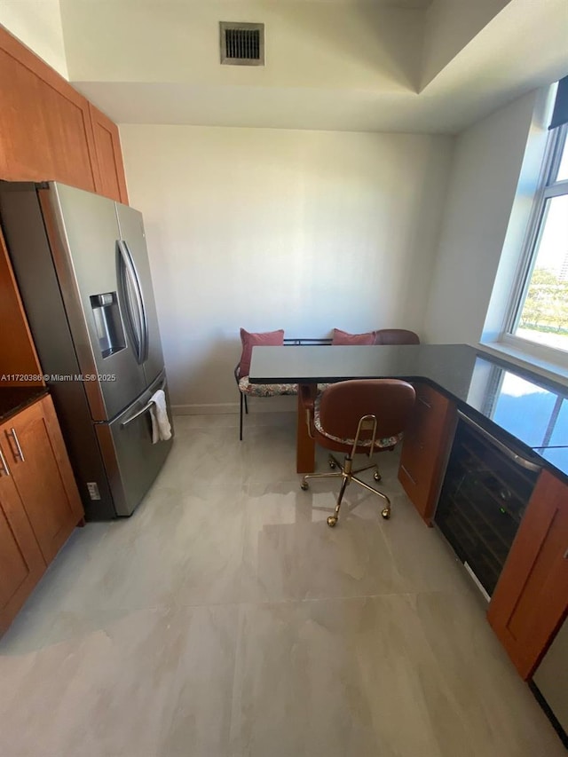 kitchen featuring stainless steel refrigerator with ice dispenser