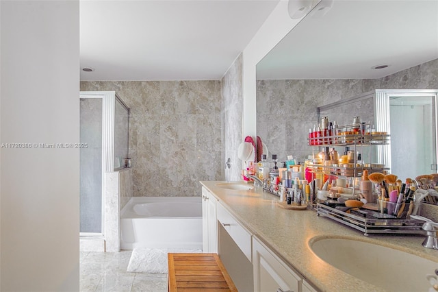 bathroom featuring plus walk in shower, vanity, tile walls, and tile patterned flooring