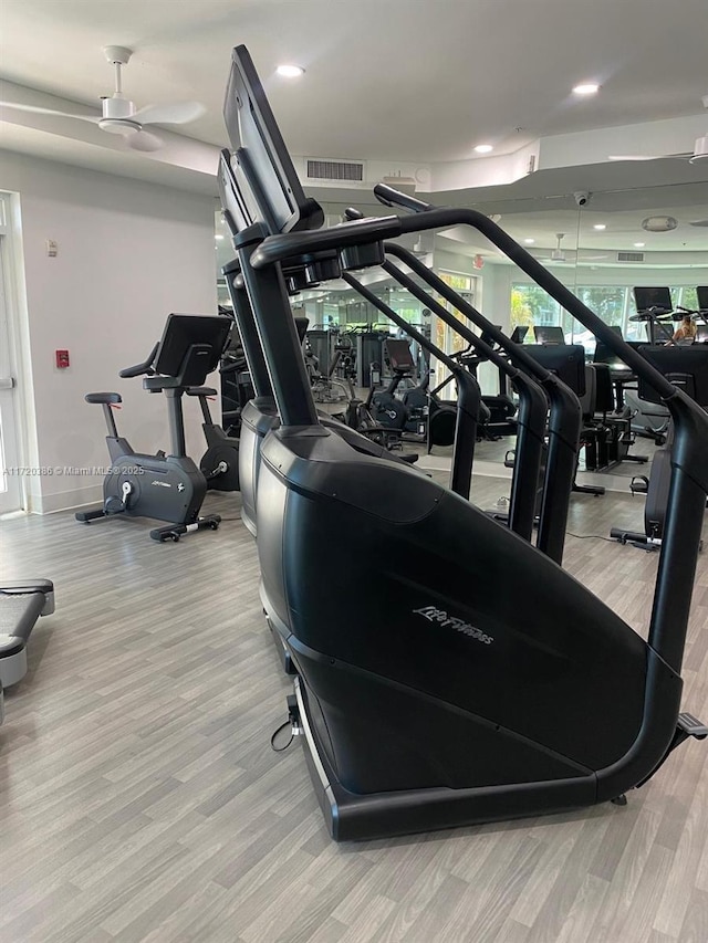 gym featuring ceiling fan and light hardwood / wood-style floors