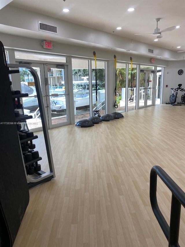 gym featuring french doors, light hardwood / wood-style flooring, and ceiling fan