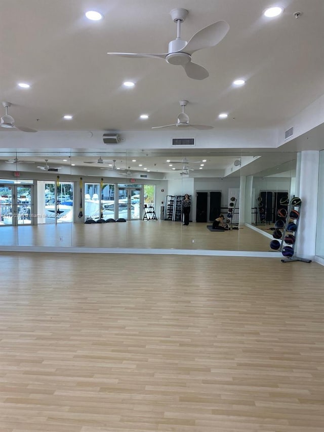 exercise room with light hardwood / wood-style floors