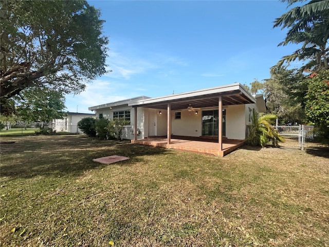 rear view of house featuring a lawn, ceiling fan, and a patio area