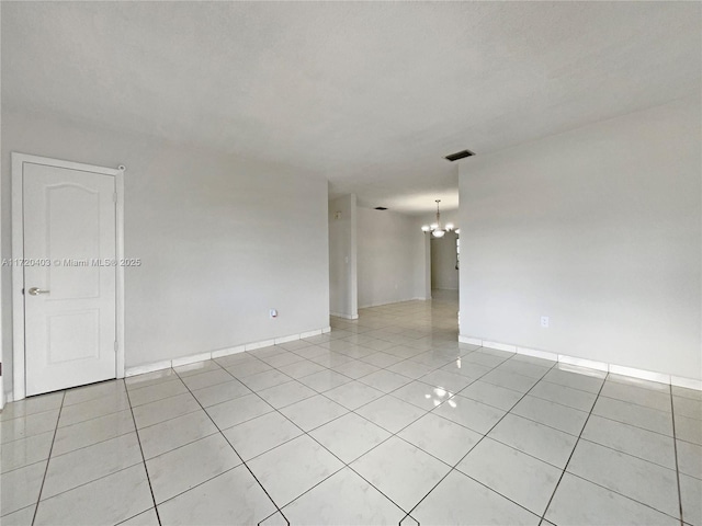 unfurnished room featuring light tile patterned floors and an inviting chandelier