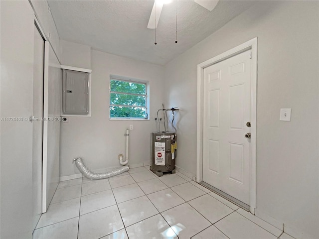 laundry room with ceiling fan, electric water heater, electric panel, a textured ceiling, and light tile patterned floors