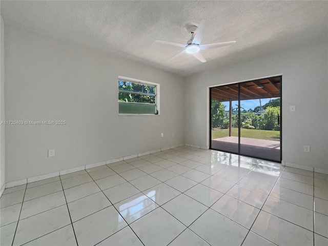 tiled spare room with ceiling fan, a healthy amount of sunlight, and a textured ceiling