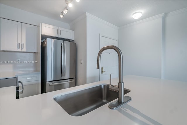 kitchen with crown molding, sink, stainless steel fridge, a textured ceiling, and white cabinetry