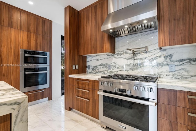 kitchen featuring wall chimney exhaust hood, decorative backsplash, and stainless steel appliances