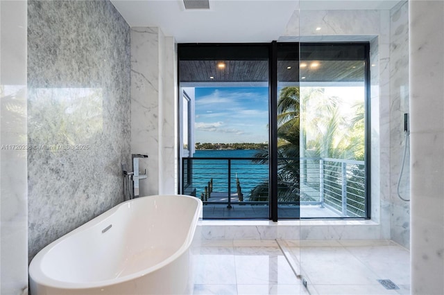 bathroom featuring a water view and a tub