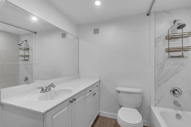 full bathroom featuring hardwood / wood-style floors, vanity, tiled shower / bath combo, and toilet