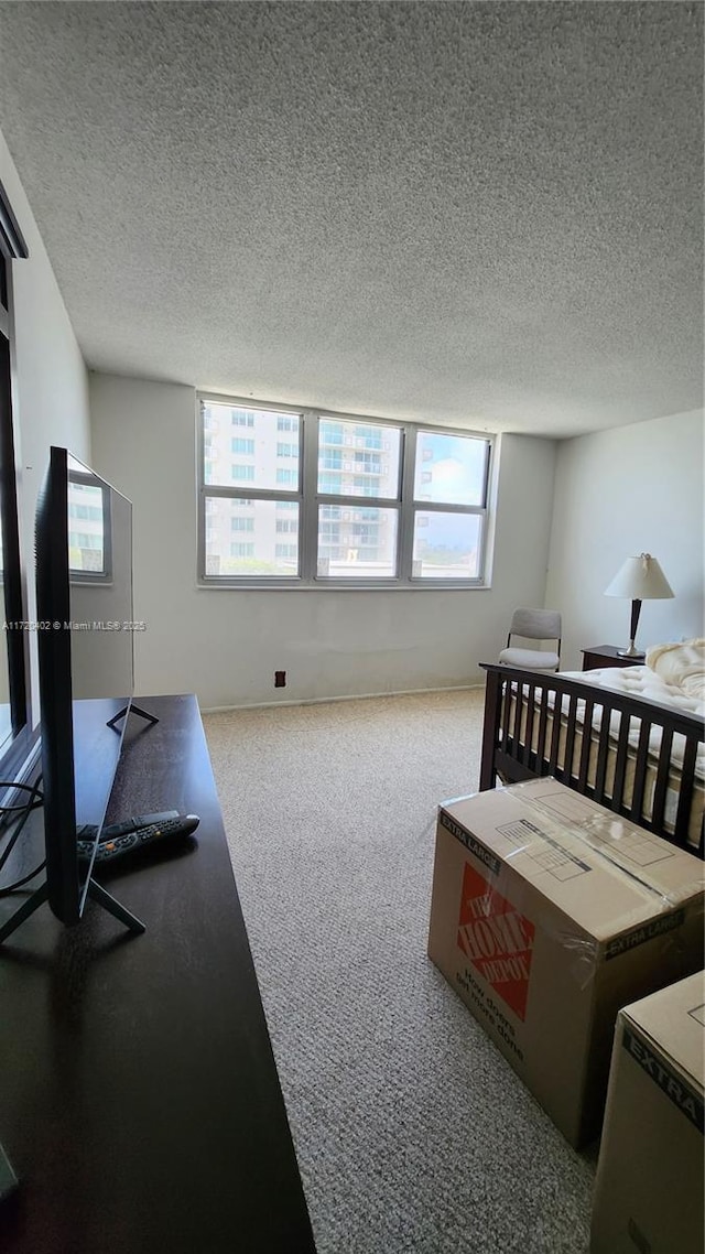 carpeted bedroom featuring a textured ceiling and multiple windows