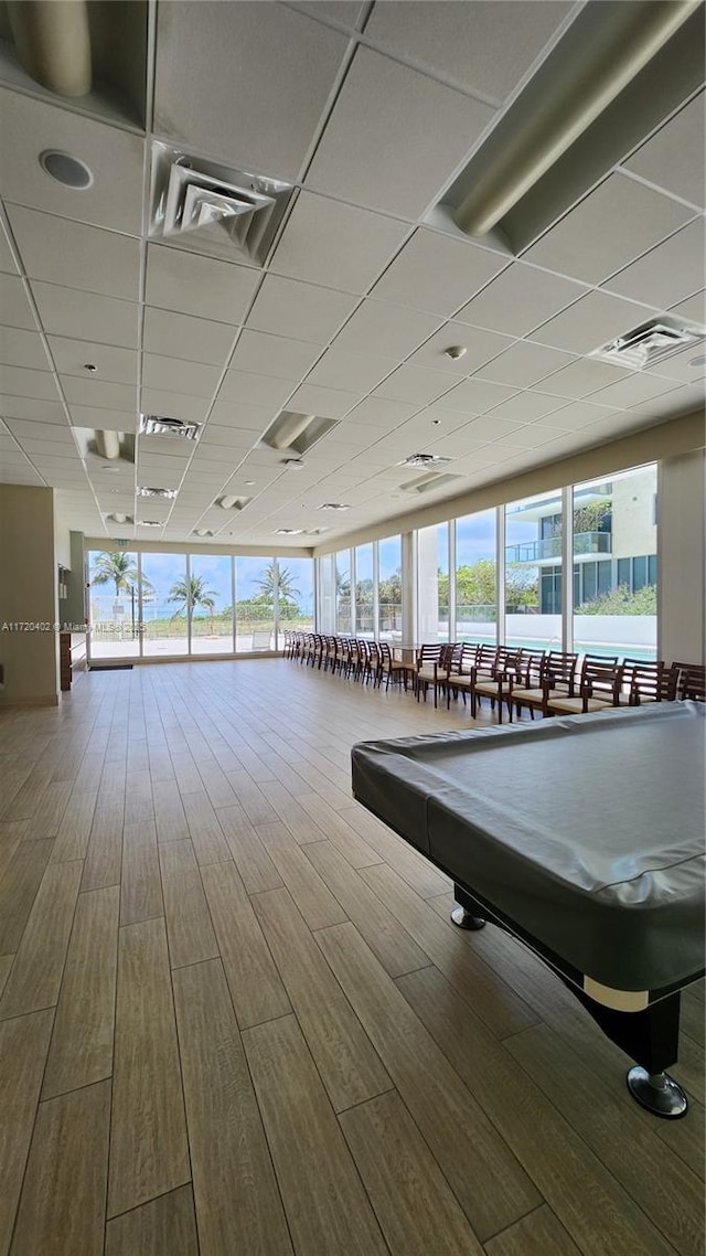 workout area with hardwood / wood-style flooring, a drop ceiling, and pool table