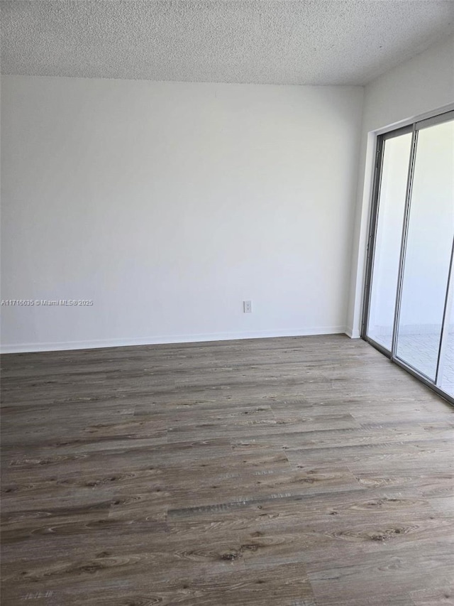 unfurnished room featuring a textured ceiling and dark wood-type flooring