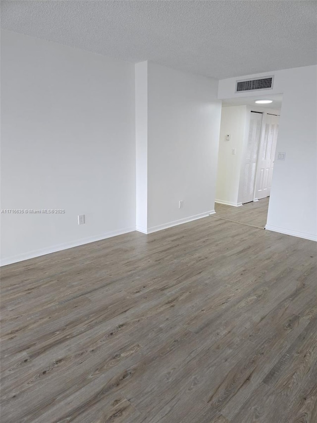 empty room featuring a textured ceiling and hardwood / wood-style flooring