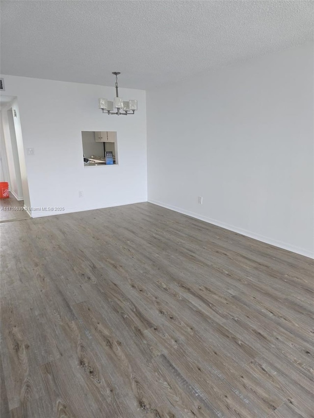 interior space with hardwood / wood-style flooring, a textured ceiling, and a chandelier