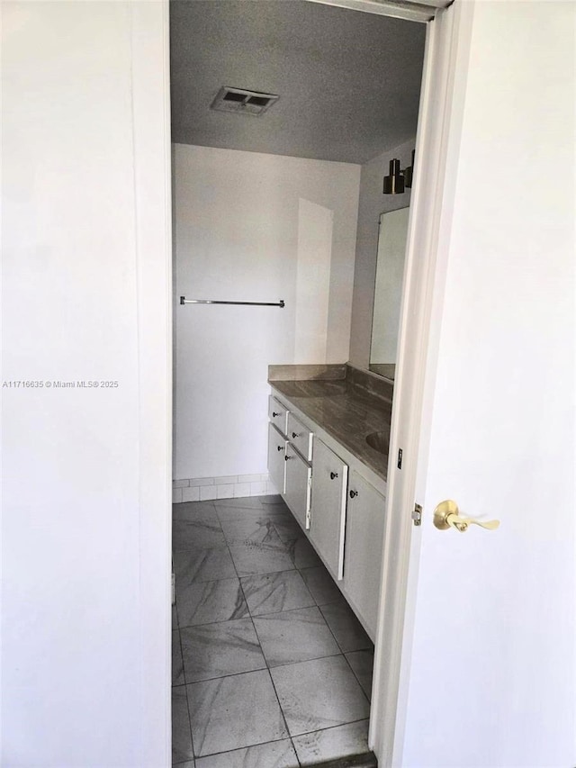 bathroom with vanity and a textured ceiling