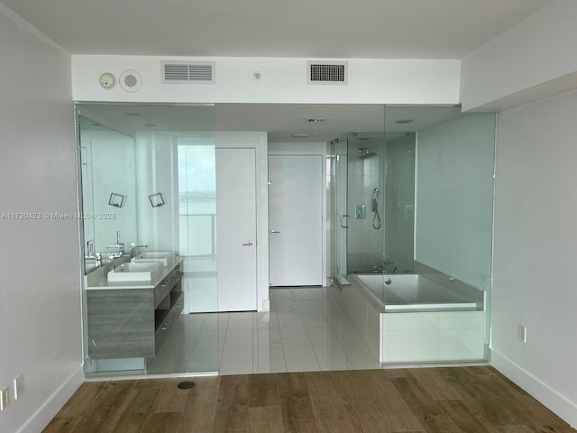 650 NE 32nd St Unit 1805, Miami, FL 33137 - full bath featuring a garden tub, double vanity, a stall shower, and wood finished floors