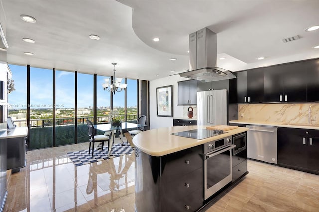 kitchen featuring island exhaust hood, appliances with stainless steel finishes, pendant lighting, a wall of windows, and a center island