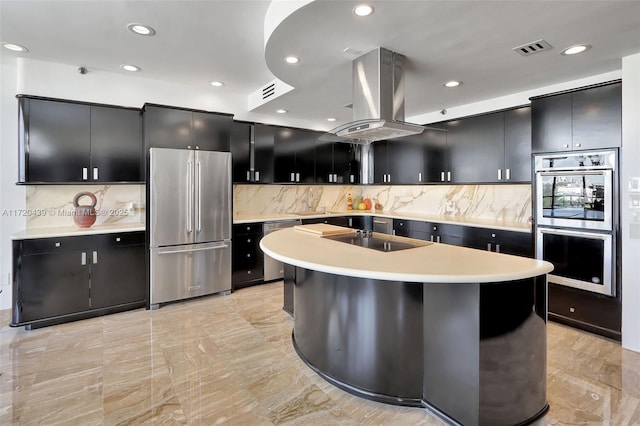 kitchen featuring decorative backsplash, extractor fan, an island with sink, and appliances with stainless steel finishes