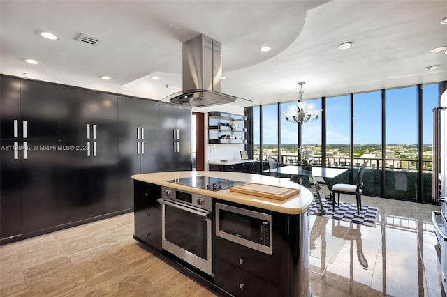 kitchen featuring island exhaust hood, expansive windows, stainless steel appliances, pendant lighting, and a center island