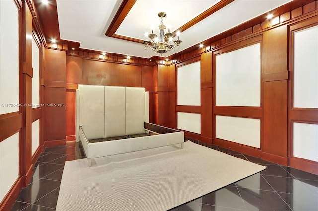 hall featuring dark tile patterned floors and a chandelier