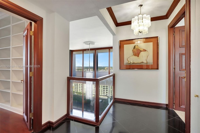 hall with a chandelier, built in shelves, a water view, and ornamental molding