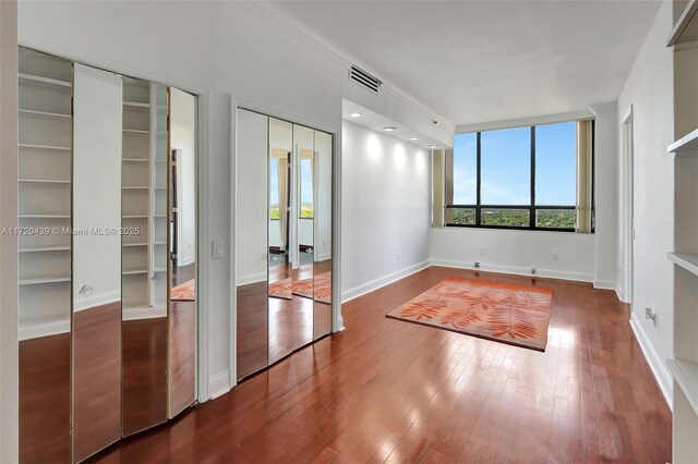 interior space with ornamental molding and dark wood-type flooring