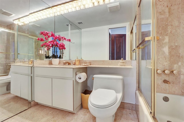 full bathroom with vanity, toilet, and bath / shower combo with glass door