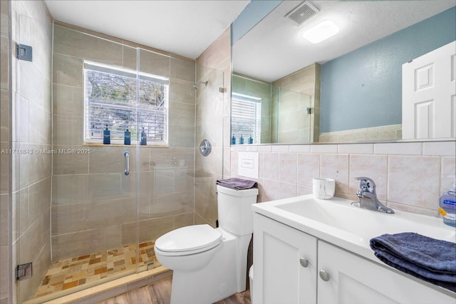 bathroom featuring decorative backsplash, an enclosed shower, vanity, hardwood / wood-style flooring, and toilet