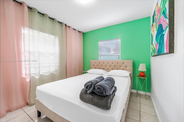 bedroom featuring light tile patterned floors and multiple windows