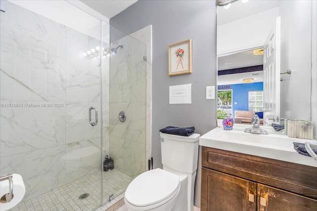 bathroom featuring vanity, toilet, and a shower with shower door