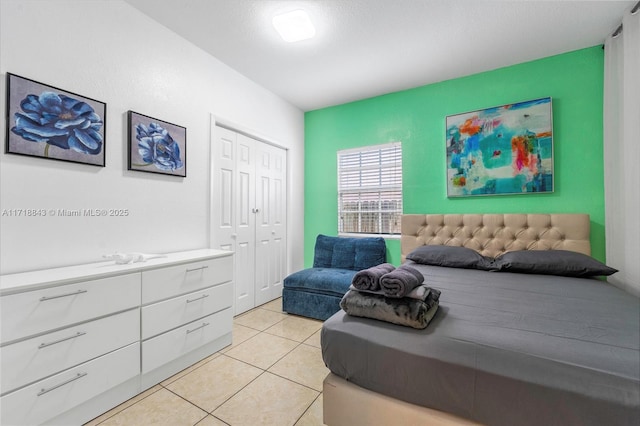 bedroom featuring light tile patterned floors and a closet