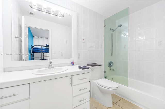 full bathroom featuring tile patterned flooring, vanity, toilet, and tiled shower / bath