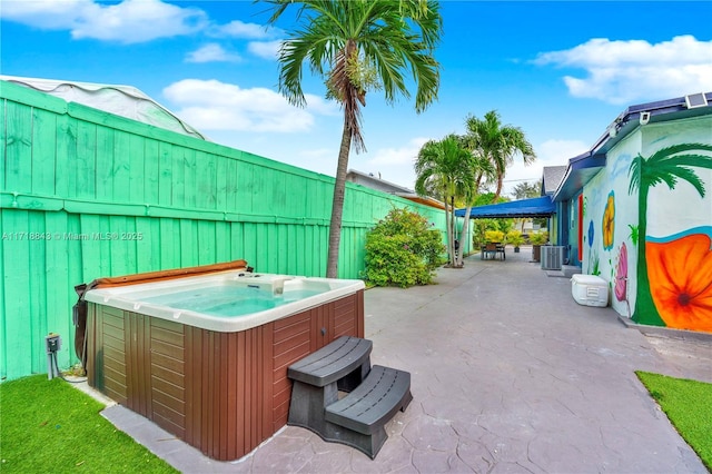 view of patio / terrace featuring cooling unit and a hot tub