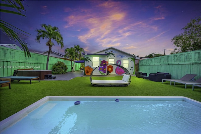 pool at dusk featuring outdoor lounge area, a patio area, and a lawn