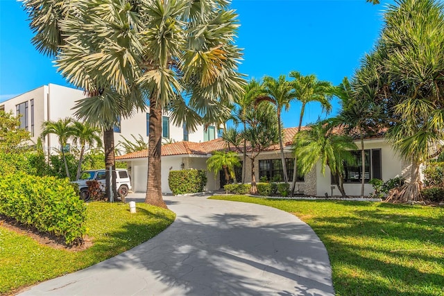 mediterranean / spanish-style house featuring a front yard