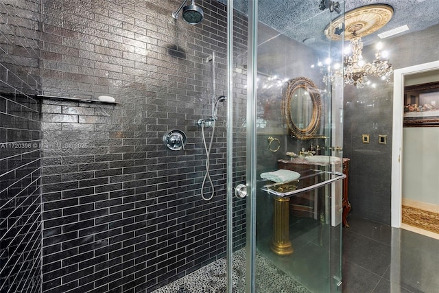 bathroom with a shower with shower door, a textured ceiling, and an inviting chandelier