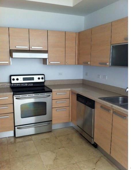 kitchen with light brown cabinetry, sink, and appliances with stainless steel finishes