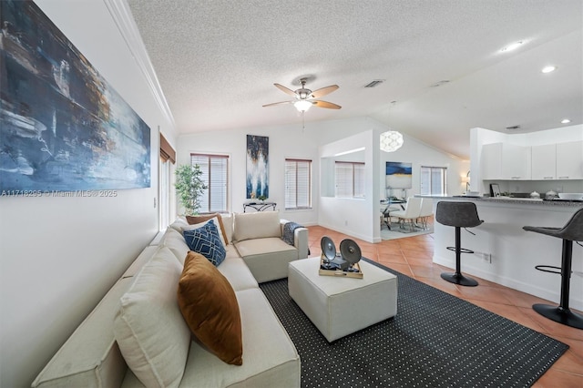 tiled living room with a textured ceiling, ceiling fan, and lofted ceiling