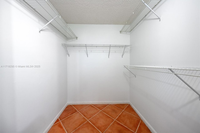 walk in closet with tile patterned floors