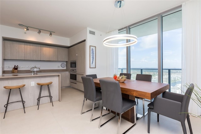 dining area with expansive windows and a water view