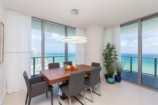 dining area with expansive windows and a water view