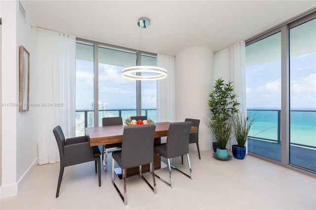 dining area with a water view and a wall of windows