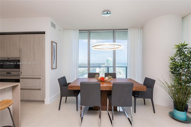 dining space with a water view and floor to ceiling windows