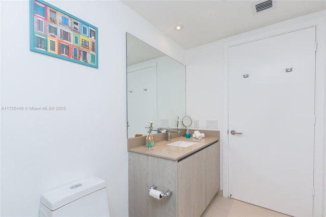 bathroom featuring tile patterned flooring, vanity, and toilet