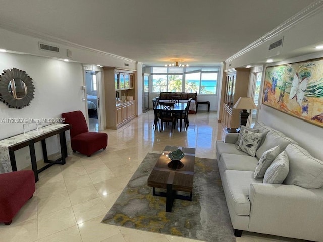 living room with light tile patterned floors, crown molding, and an inviting chandelier