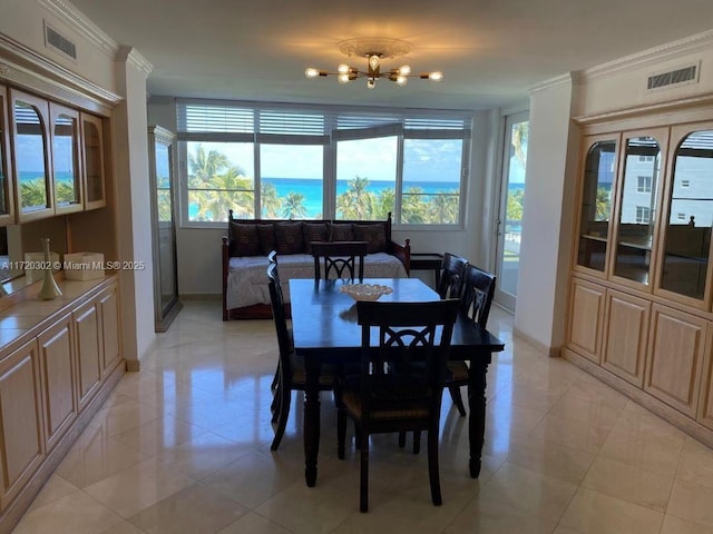 tiled dining area with crown molding and a notable chandelier