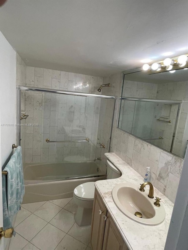 full bathroom with vanity, tile patterned flooring, toilet, enclosed tub / shower combo, and tile walls