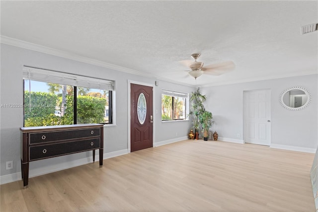 foyer entrance featuring a textured ceiling, ceiling fan, crown molding, and light hardwood / wood-style flooring