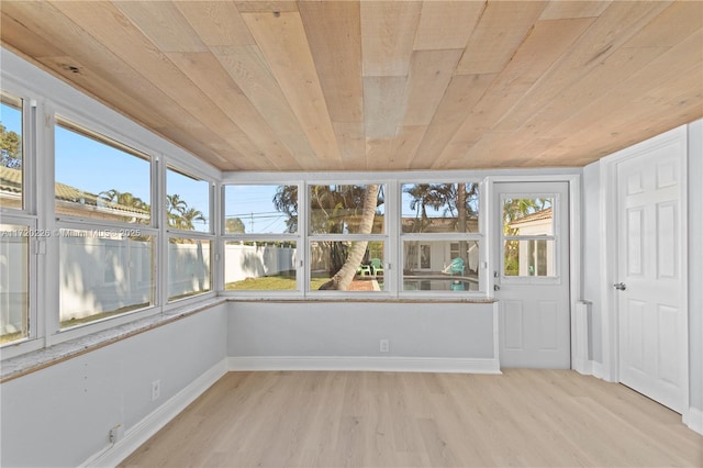 unfurnished sunroom with a healthy amount of sunlight and wooden ceiling